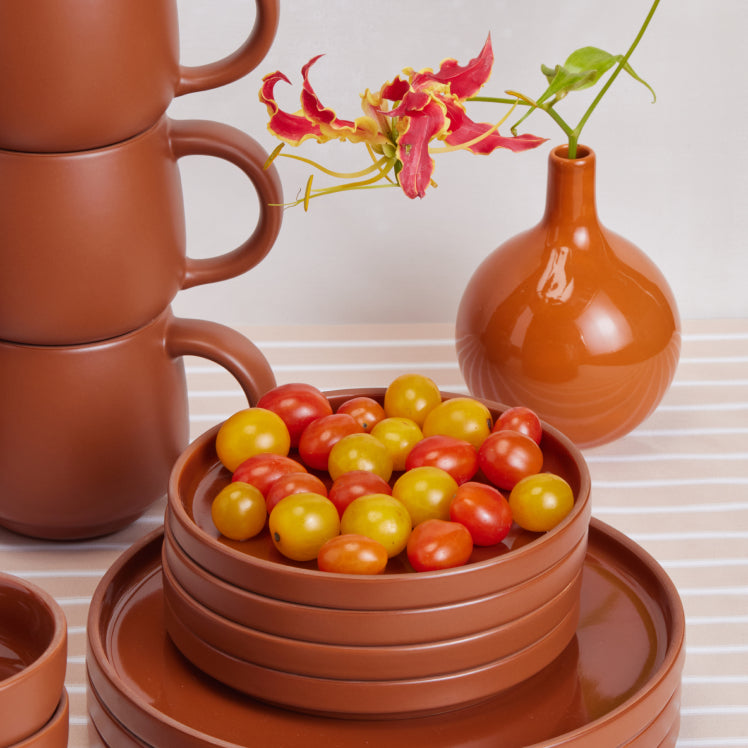 Stacked_terracotta_mugs_and_dessert_plates_with_tomatoes.jpg